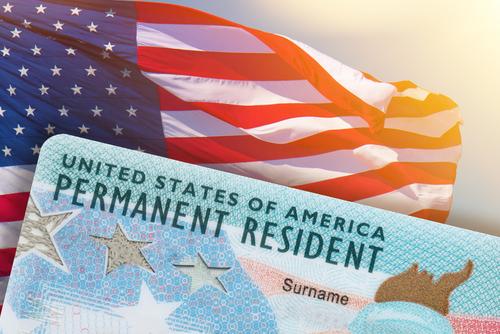 Green card (permanent resident) in front of USA flag
